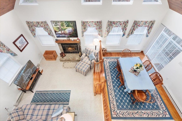 130 Rainier Rd, Mcgaheysville, VA 22840 - living area featuring a baseboard heating unit, plenty of natural light, a lit fireplace, a towering ceiling, and wood finished floors
