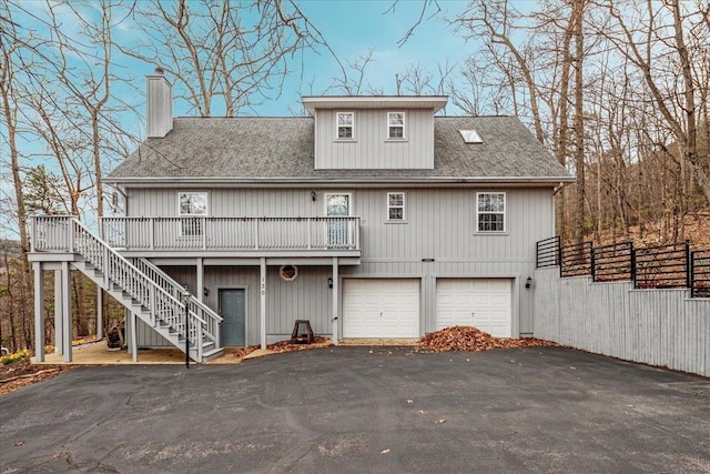 130 Rainier Rd, Mcgaheysville, VA 22840 - back of property with stairway, a chimney, asphalt driveway, a garage, and a wooden deck