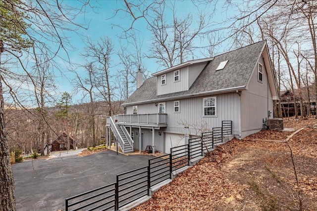 130 Rainier Rd, Mcgaheysville, VA 22840 - back of property with driveway, stairs, a shingled roof, an attached garage, and a wooden deck