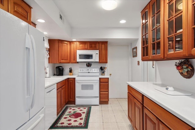 130 Rainier Rd, Mcgaheysville, VA 22840 - kitchen featuring white appliances, light countertops, brown cabinetry, glass insert cabinets, and recessed lighting