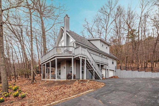 130 Rainier Rd, Mcgaheysville, VA 22840 - view of front of home with a chimney, a wooden deck, stairway, asphalt driveway, and roof with shingles