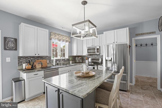 2609 Melissa Ct, Fredericksburg, VA 22408 - kitchen featuring appliances with stainless steel finishes, a sink, tasteful backsplash, a center island, and white cabinets