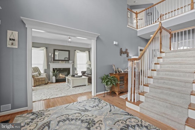 2609 Melissa Ct, Fredericksburg, VA 22408 - foyer with stairway, wood finished floors, a glass covered fireplace, baseboards, and a high ceiling