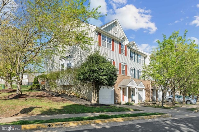 townhome / multi-family property with an attached garage and asphalt driveway