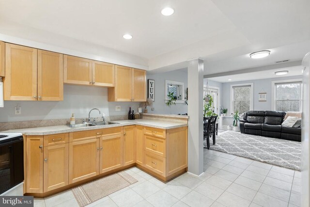 kitchen featuring light brown cabinetry, sink, electric range, and light tile patterned floors