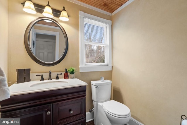 bathroom with vanity, crown molding, and toilet