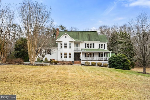 greek revival inspired property featuring a porch and a front lawn