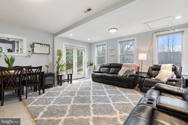 living room with french doors, plenty of natural light, and light tile patterned floors