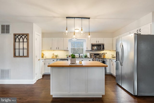 kitchen featuring wood counters, a kitchen island, white cabinets, and appliances with stainless steel finishes