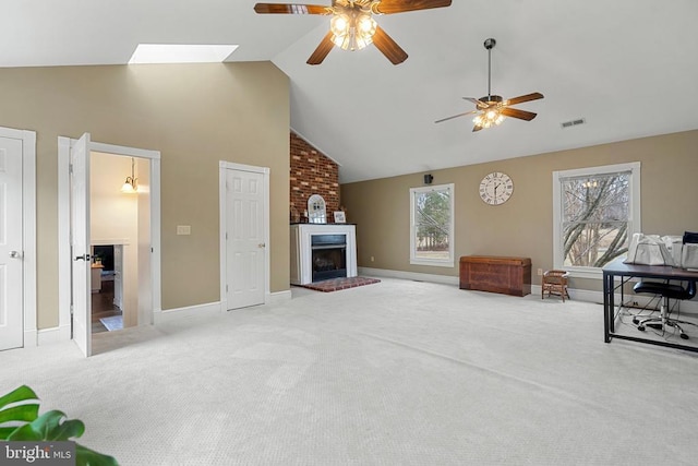 carpeted living room with a brick fireplace, high vaulted ceiling, and ceiling fan