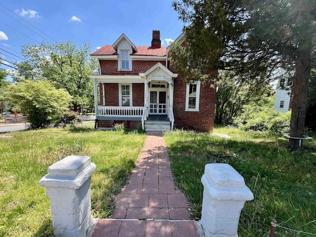 view of front of property with brick siding, a chimney, and a porch