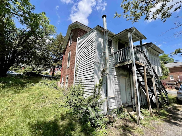 view of property exterior with stairs and brick siding