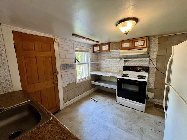 kitchen featuring electric stove, freestanding refrigerator, a sink, under cabinet range hood, and light flooring