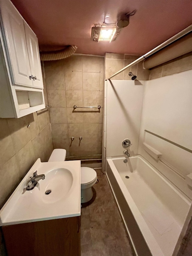 bathroom featuring toilet, tile walls, shower / bathtub combination, and vanity