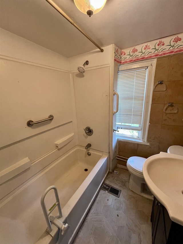 full bathroom featuring toilet, tile walls, bathtub / shower combination, and vanity