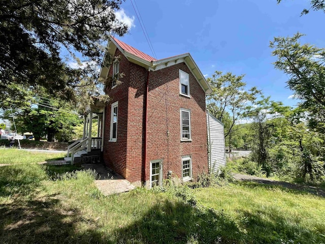 view of home's exterior with brick siding and metal roof