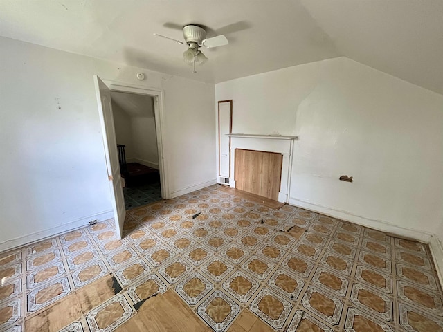 unfurnished living room with ceiling fan and vaulted ceiling