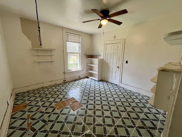 unfurnished room with a ceiling fan and baseboards