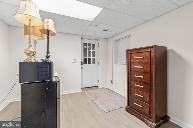 entryway with baseboards, a drop ceiling, and wood finished floors