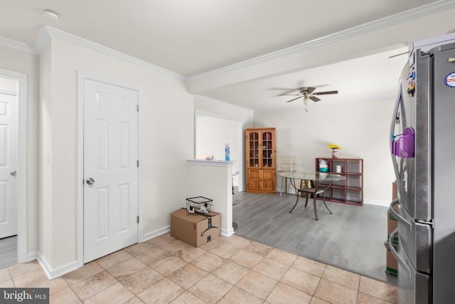 kitchen featuring freestanding refrigerator, baseboards, a ceiling fan, ornamental molding, and tile patterned floors