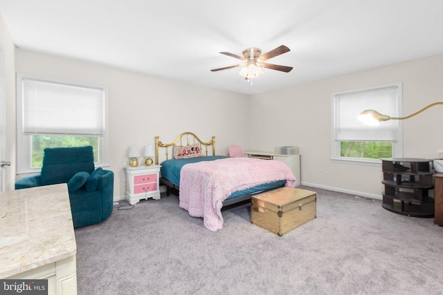 carpeted bedroom featuring baseboards and a ceiling fan
