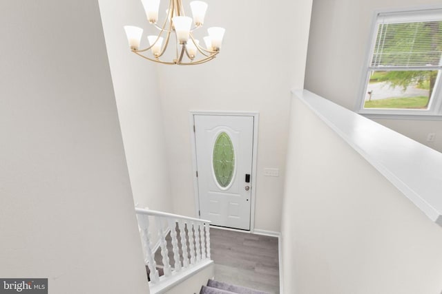 foyer entrance with a chandelier and wood finished floors
