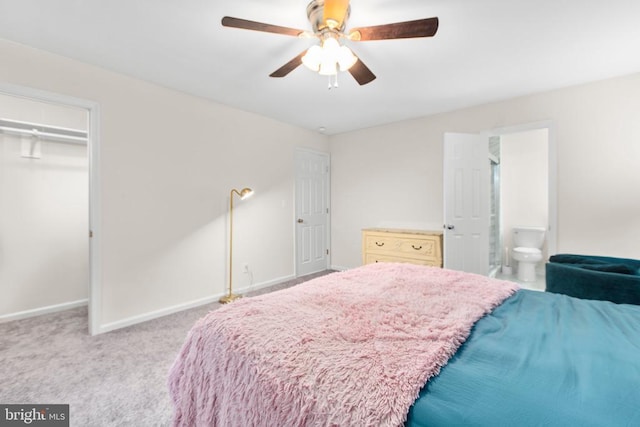 carpeted bedroom featuring baseboards, ensuite bathroom, ceiling fan, and a closet