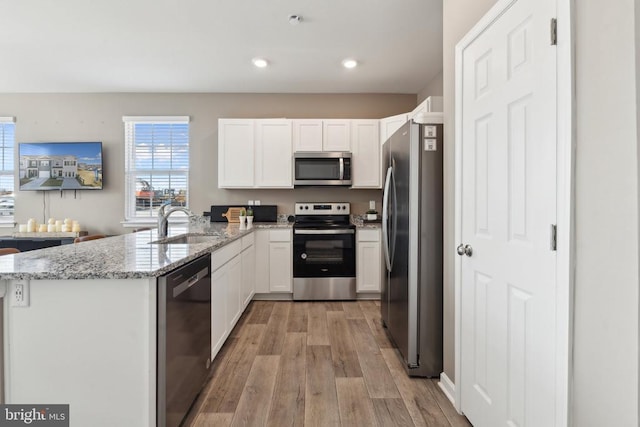139 Rae Ct, Luray, VA 22835 - kitchen featuring stainless steel appliances, a peninsula, light wood-style flooring, white cabinets, and light stone counters