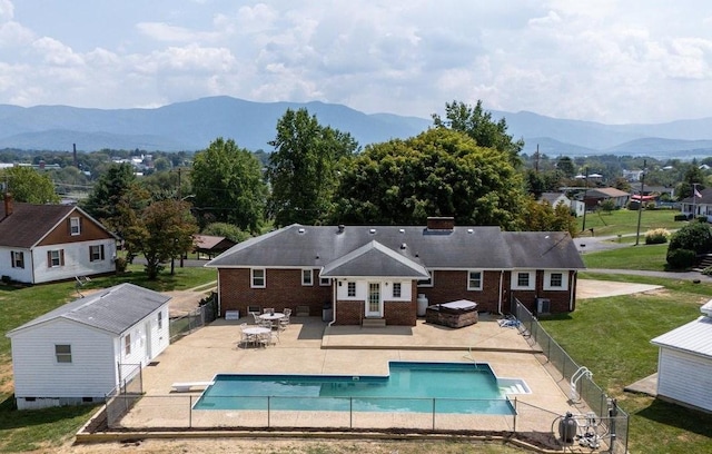 back of house with a mountain view, a patio area, and brick siding