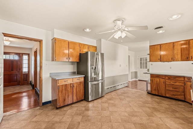 kitchen with baseboard heating, stainless steel refrigerator with ice dispenser, brown cabinets, a ceiling fan, and recessed lighting