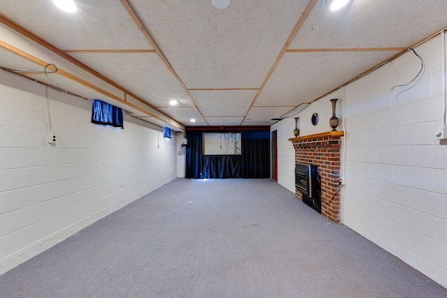 basement with a brick fireplace, carpet flooring, and recessed lighting