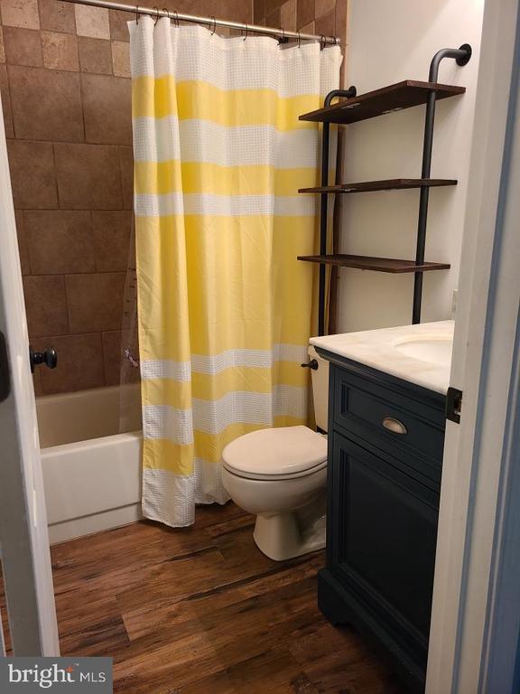 11934 Gardenia Dr, Fredericksburg, VA 22407 - full bathroom featuring toilet, wood finished floors, vanity, and shower / tub combo with curtain
