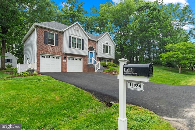 11934 Gardenia Dr, Fredericksburg, VA 22407 - split foyer home featuring asphalt driveway, an attached garage, a front yard, and brick siding
