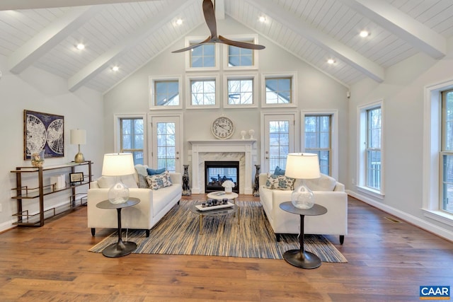 living room featuring hardwood / wood-style floors, beam ceiling, a fireplace, and high vaulted ceiling