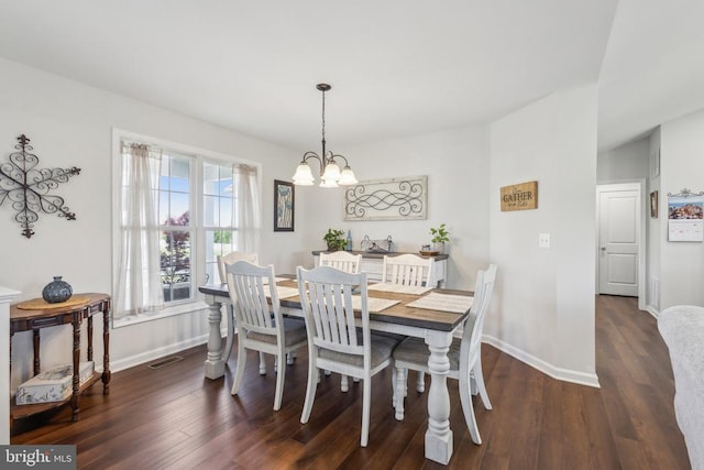 dining area featuring a chandelier, wood finished floors, and baseboards
