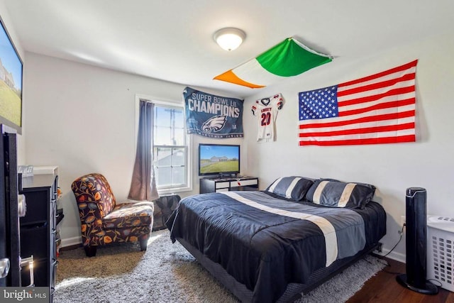 bedroom featuring baseboards and wood finished floors