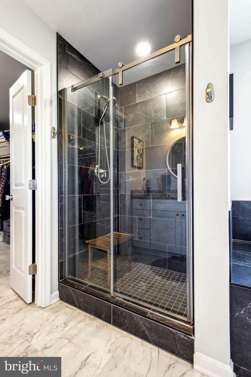 full bath featuring marble look tiles, a shower stall, vanity, recessed lighting, and a spacious closet