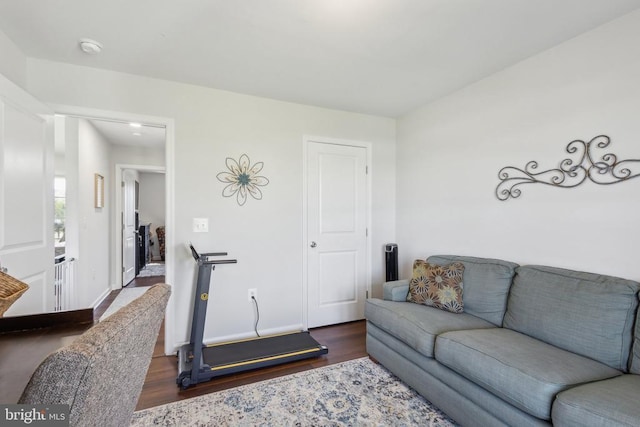 living area with dark wood-type flooring and baseboards