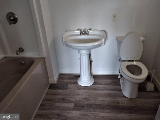 33 Circle Rd E, Madison, VA 22727 - bathroom with baseboards, wood finished floors, a bathtub, and toilet