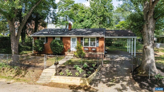 122 Westerly Ave, Charlottesville, VA 22903 - view of front facade featuring a chimney, an attached carport, a fenced front yard, brick siding, and driveway