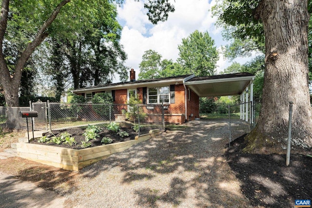 122 Westerly Ave, Charlottesville, VA 22903 - view of front of home with a chimney, brick siding, a garden, a carport, and driveway