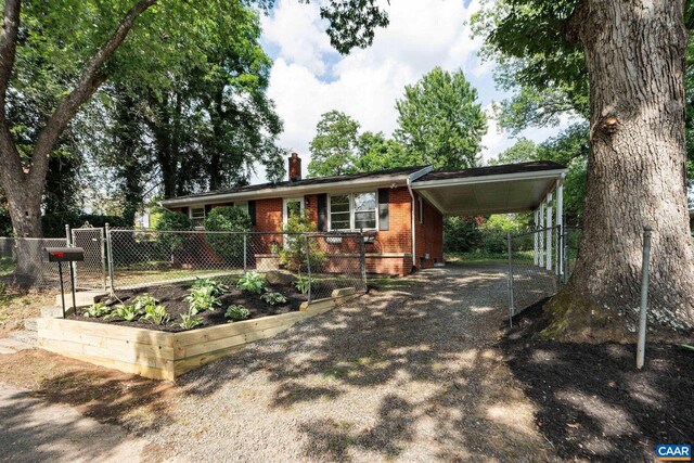 122 Westerly Ave, Charlottesville, VA 22903 - view of front of home with a chimney, brick siding, a garden, a carport, and driveway