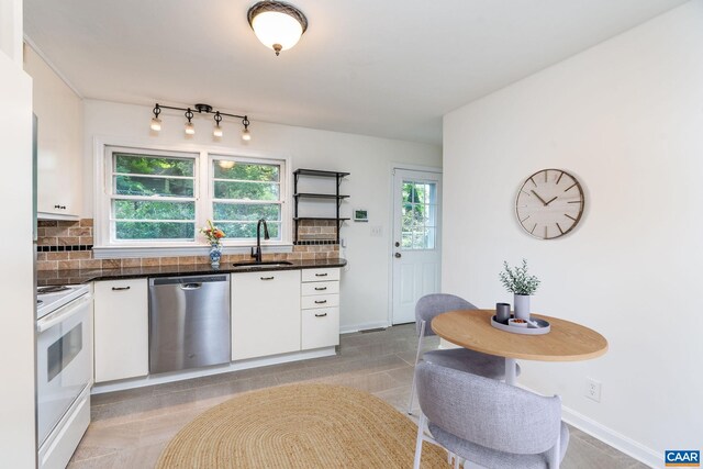 122 Westerly Ave, Charlottesville, VA 22903 - kitchen with stainless steel dishwasher, white electric range oven, white cabinetry, dark countertops, and decorative backsplash