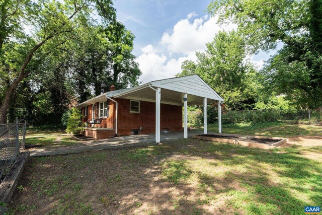 122 Westerly Ave, Charlottesville, VA 22903 - view of side of home with brick siding, an attached carport, and a vegetable garden