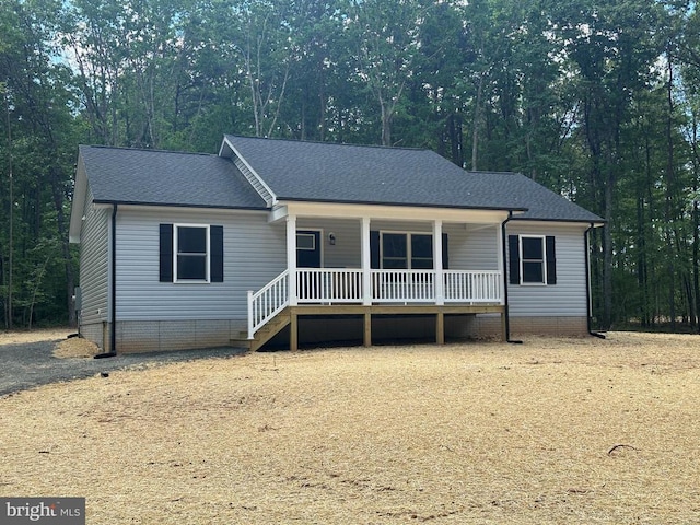 view of front facade with a porch, roof with shingles, and crawl space