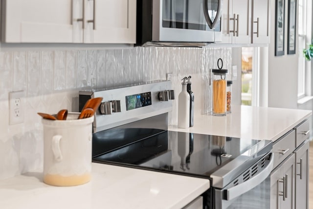 kitchen featuring stainless steel appliances, light countertops, and decorative backsplash