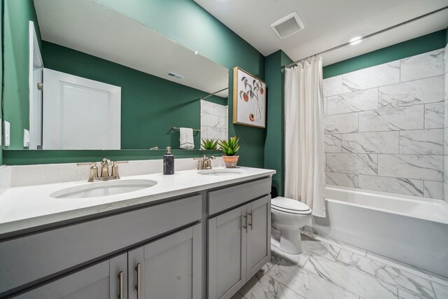 bathroom with toilet, double vanity, marble finish flooring, and shower / bath combo with shower curtain