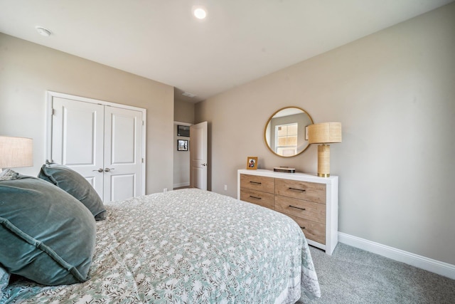 bedroom with light colored carpet, baseboards, and a closet