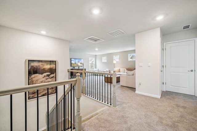 hall with an upstairs landing, attic access, carpet flooring, recessed lighting, and baseboards