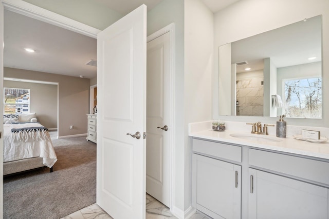 ensuite bathroom featuring marble finish flooring, plenty of natural light, vanity, a tile shower, and recessed lighting